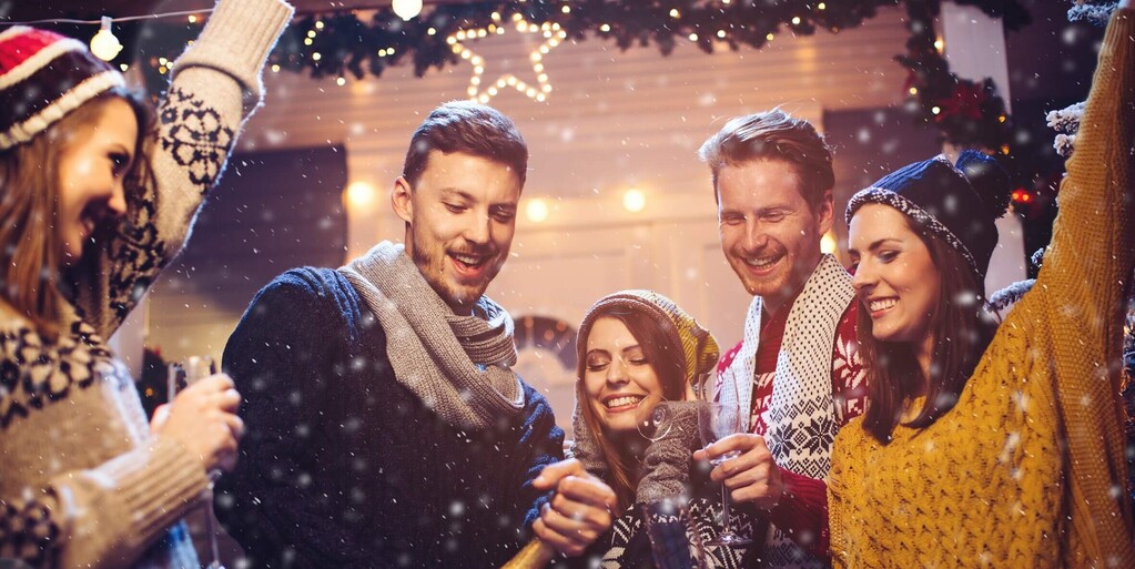 Junge Menschen feiern gemeinsam mit Glitzer und Wein – festliche Werbestimmung.